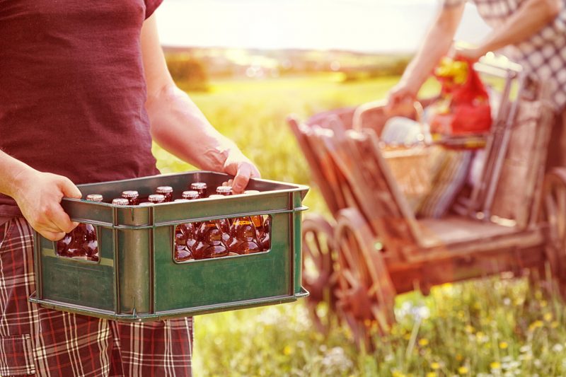 2 Männer mit Bierkasten und Bollerwagen