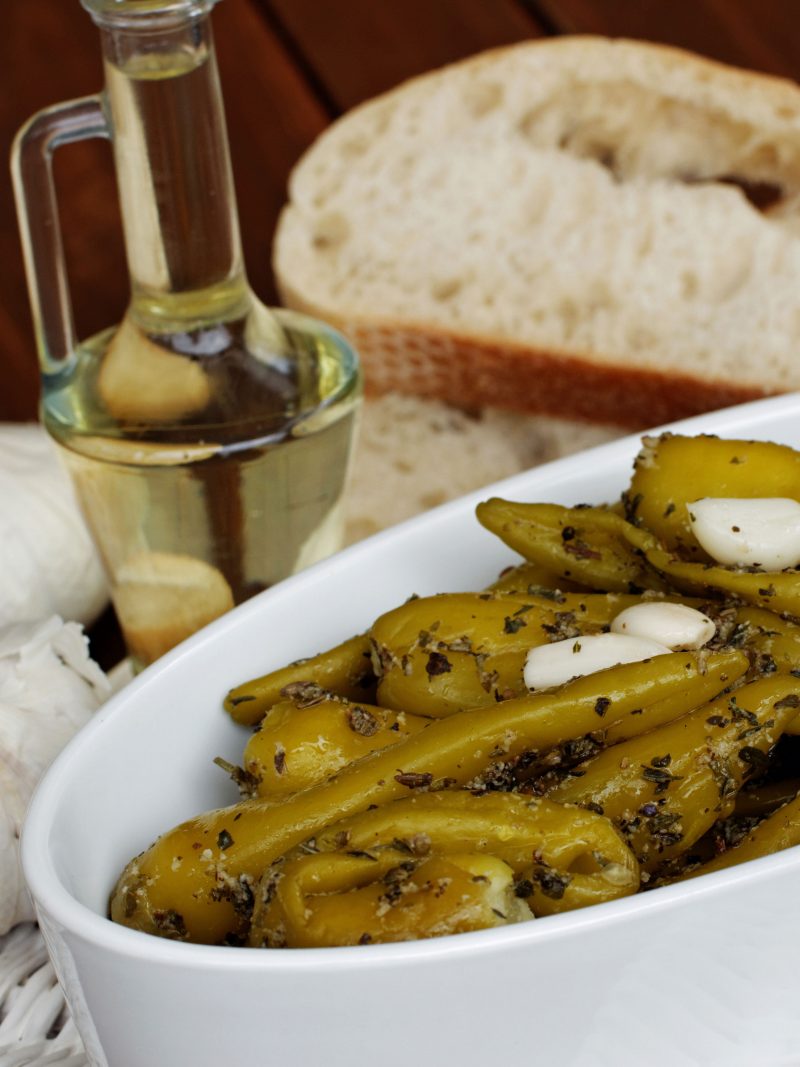 Gegrillte Peperoni, angerichtet mit Brot und Knoblauch