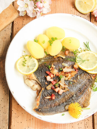 Gebratene Scholle mit Speck und Kartoffeln auf Teller