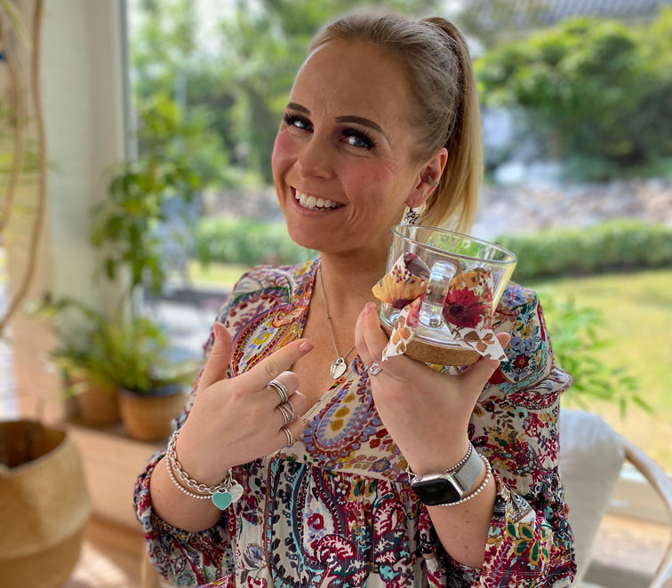 Katharina mit einem Glas mit Henkelschleife in der Hand