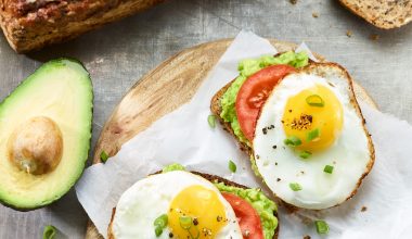 Dinkelbrot mit Avocado und Spiegelei auf Holzbrett