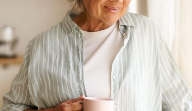 Frau mit Kaffeetasse schaut aus dem Fenster