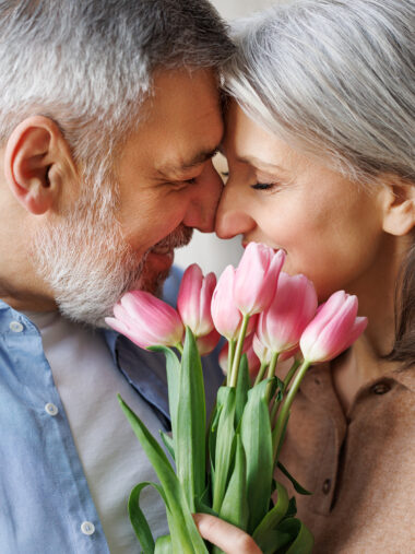 Verliebtes Pärchen Nase an Nase mit Blumen