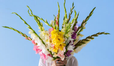 Frau mit Gladiolenstrauß im Arm
