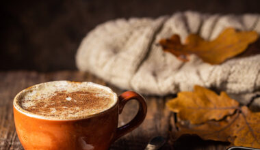 Kaffee und Kopfhörer liegen in einem herbstlich-rustikalen Ambiente