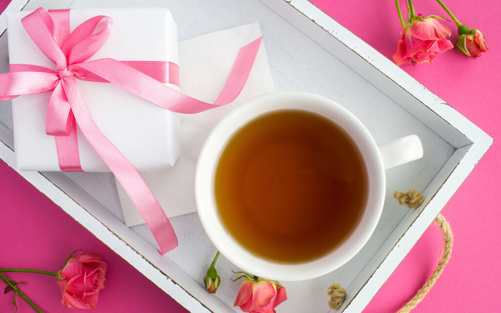 Tee mit Geschenk und Blumen
