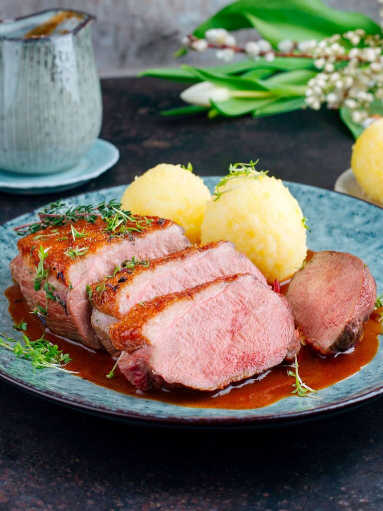 Entenfilet auf dem Teller angerichtet mit Klößen und Sauce