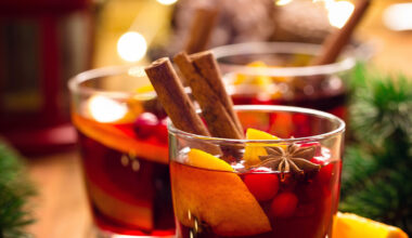 Gläser mit traditionellem Weihnachtspunsch auf Holztisch