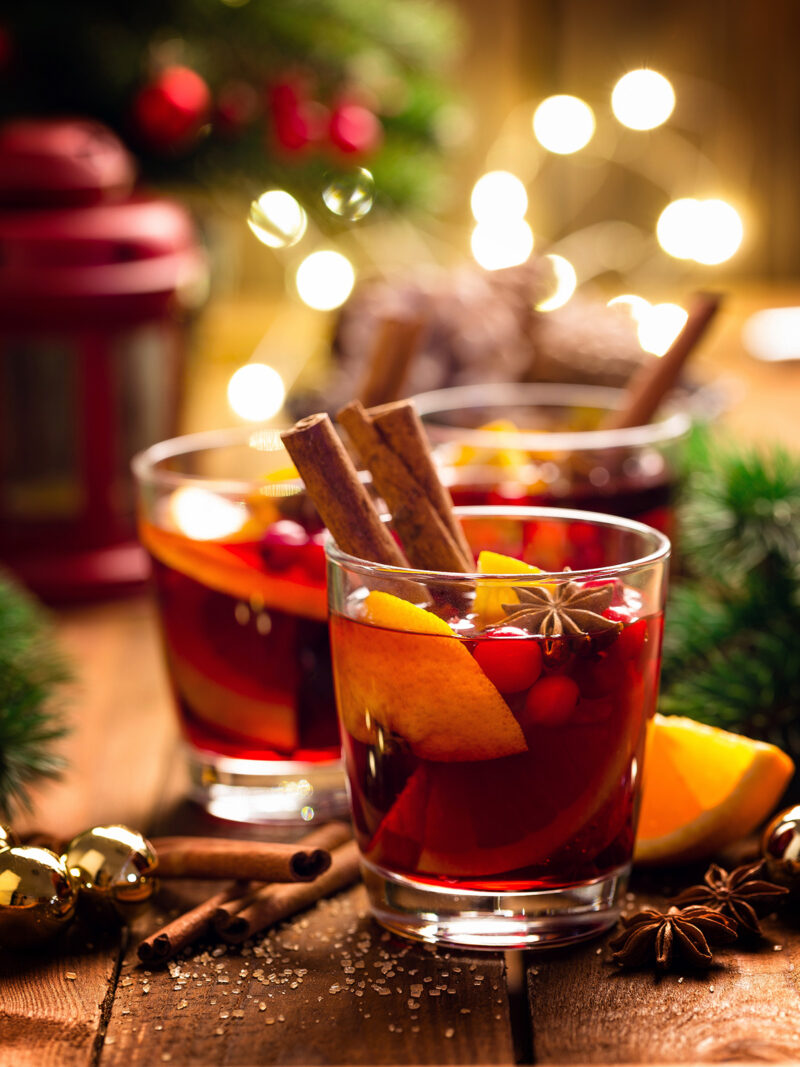 Gläser mit traditionellem Weihnachtspunsch auf Holztisch