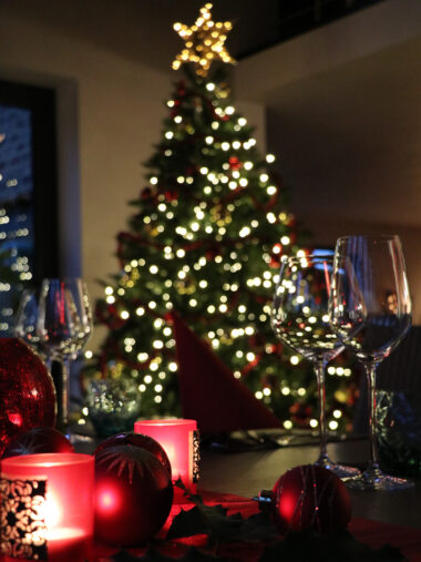 Festtafel vor leuchtendem Weihnachtsbaum