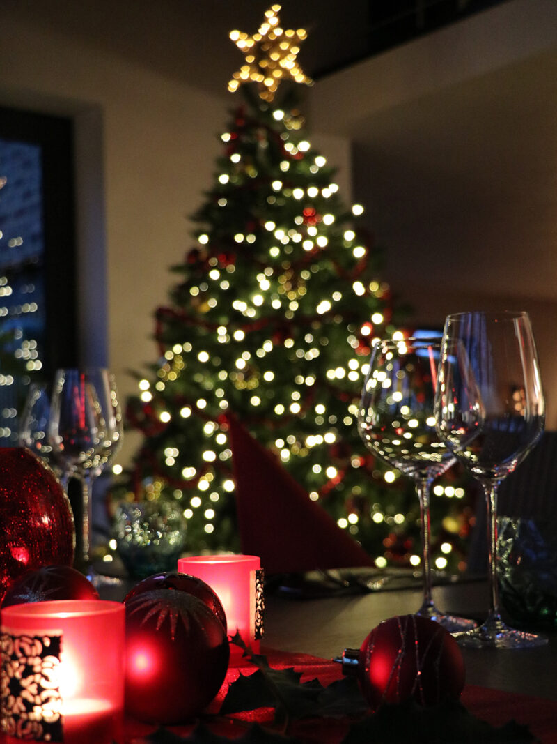 Festtafel vor leuchtendem Weihnachtsbaum