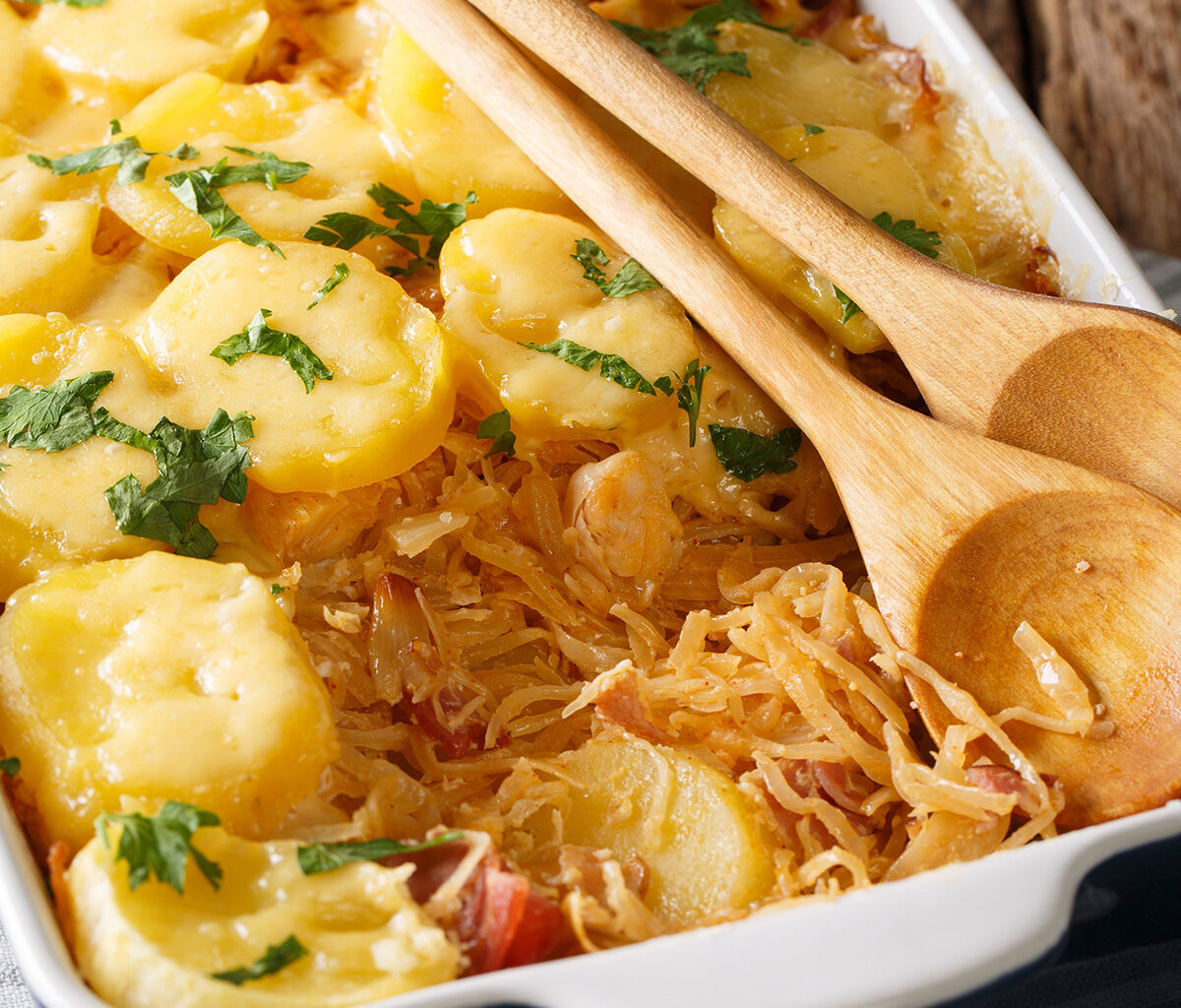 Kasserole mit Sauerkrautauflauf und Holzlöffel
