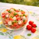 Melonen-Feta-Salat in einer Schüssel, daneben Tomaten
