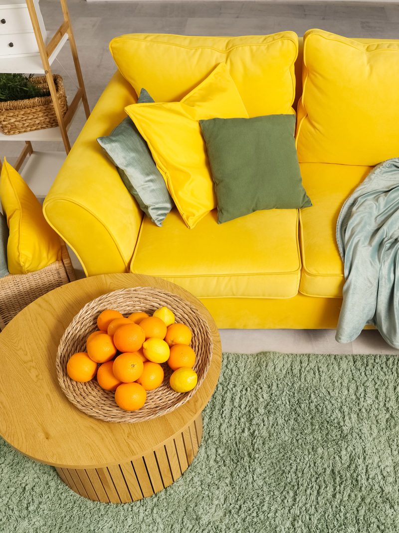 Eine Wohnecke mit Sofa und Beistellstisch im gelb-grünen Farbschema der Zitrone