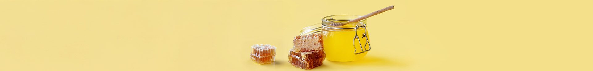 Honig im Glas mit Löffel und Honigwaben