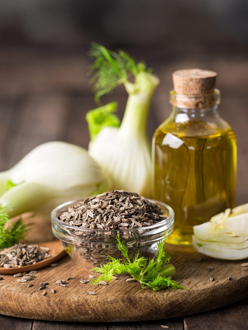 Fenchel, Öl und Samen auf einem Brettchen