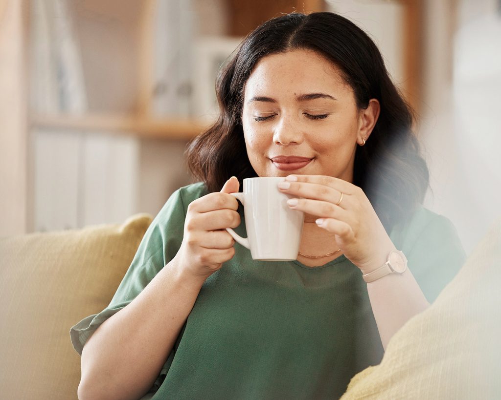 Frau mit Tasse in der Hand genießt ihren Kaffee