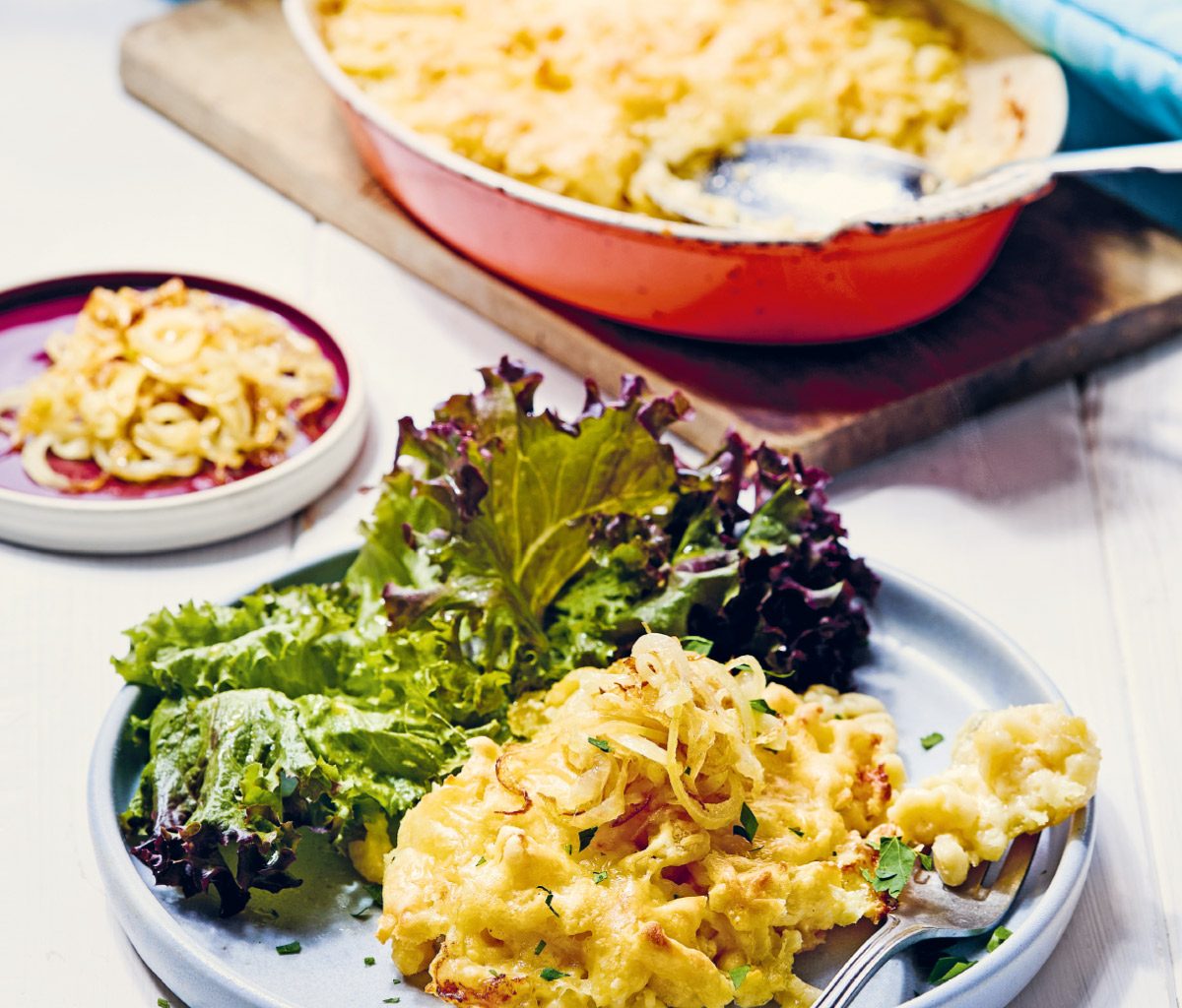Fränkische Käsespätzle mit Salat auf einem weißen Teller