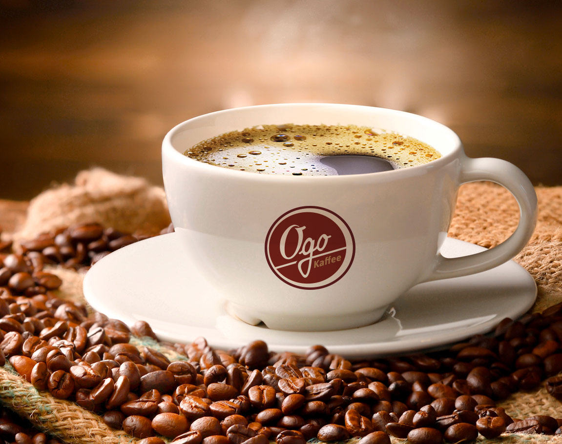 Tasse Ogo Kaffee auf Untertasse mit geTasse Ogo Kaffee auf Untertasse mit gerösteten Bohnenrösteten Bohnen