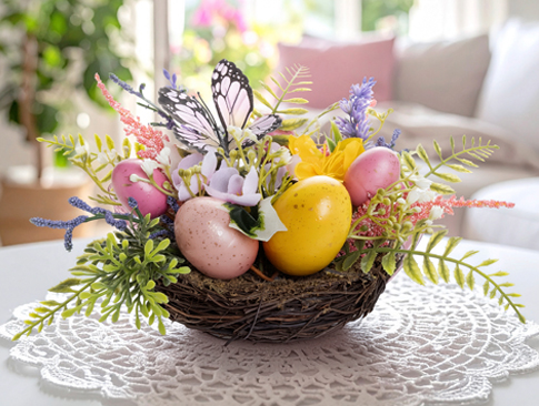Osterdeko mit Kunstblumen, Eiern und Schmetterling im Nest