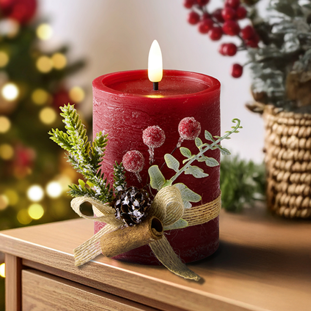 Rote Weihnachtskerze mit Deko und Tannenzweig