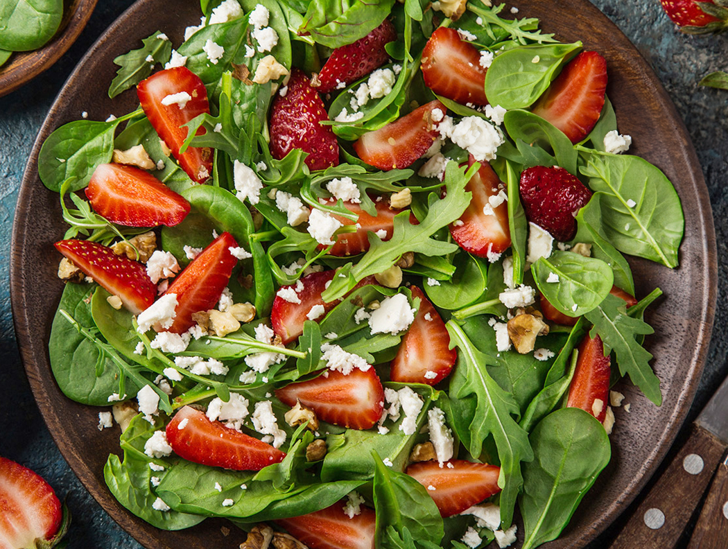 Erdbeer-Feta-Salat mit Rucola, Spinat und Walnüssen, frisch serviert in Schale