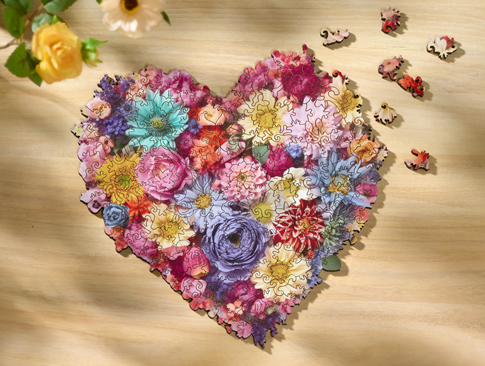 Herzförmiges Blumenpuzzle auf einem Holztisch