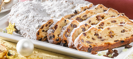 Weihnachtlicher Stollen mit Rosinen und Puderzucker auf Servierplatte