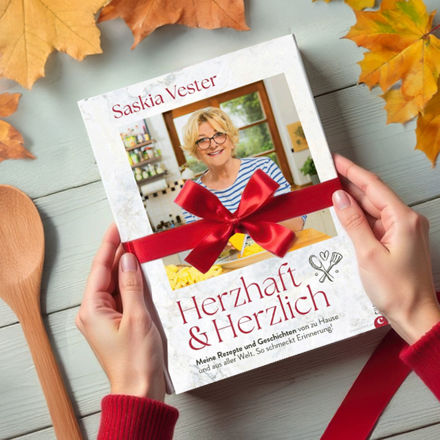 Buchgeschenk mit roter Schleife und Kochutensilien