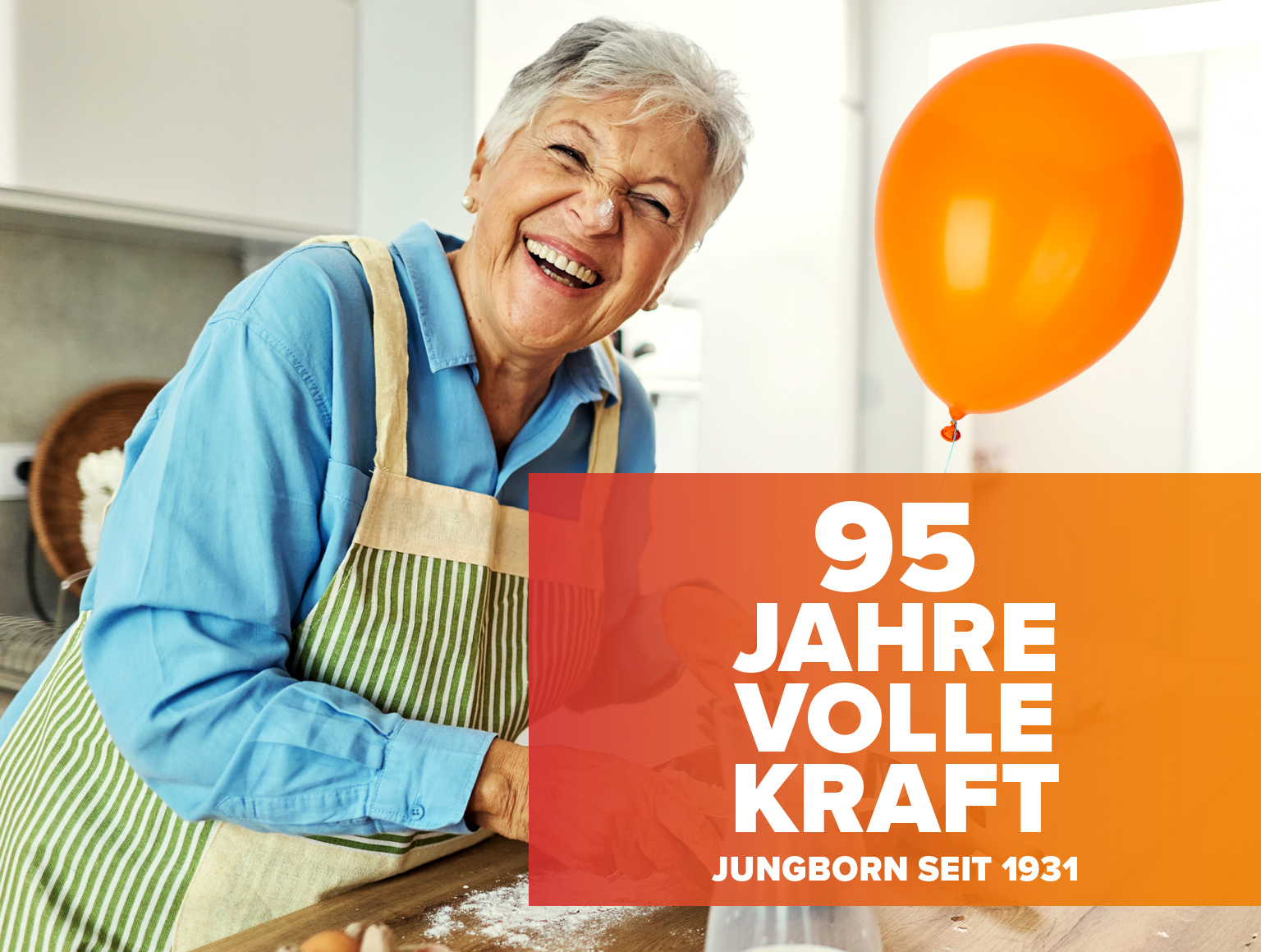 Lachende Seniorin in Küche mit Schriftzug „95 Jahre volle Kraft“
