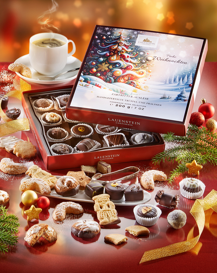 Edle Pralinen und Gebäck auf weihnachtlich gedecktem Tisch