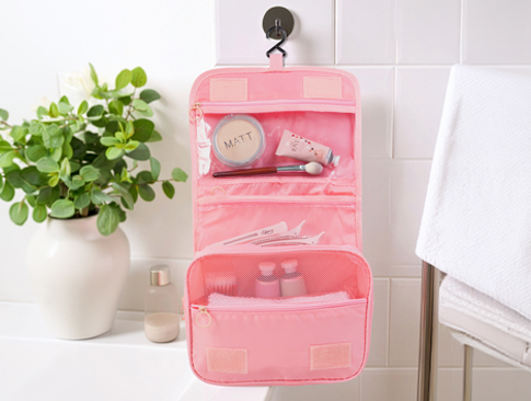 Hängende Kosmetiktasche mit Fächern und Pflegeprodukten im Bad