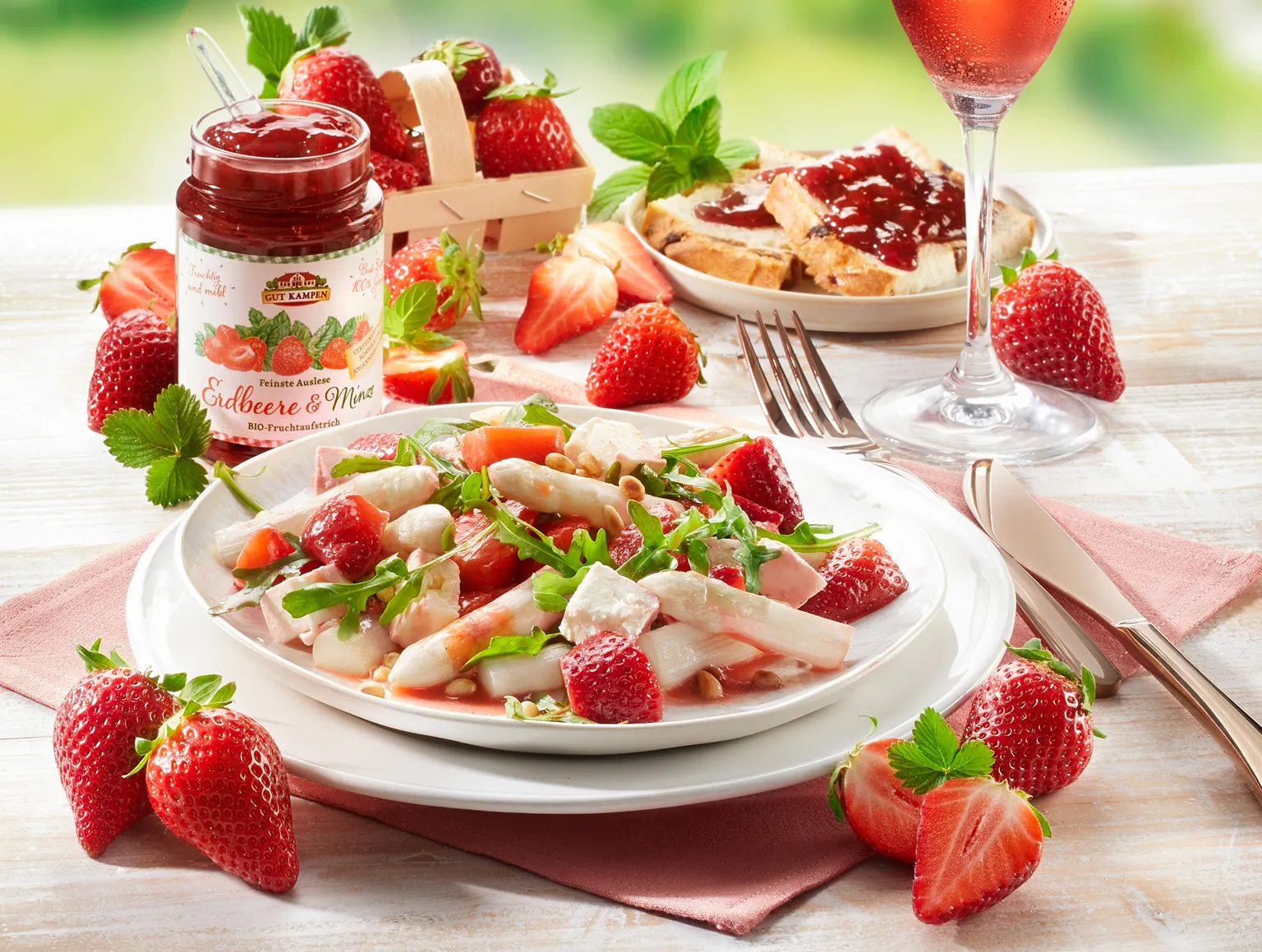 BIO Erdbeer-Konfitüre mit frischen Erdbeeren, Toast und Salat auf Holztisch