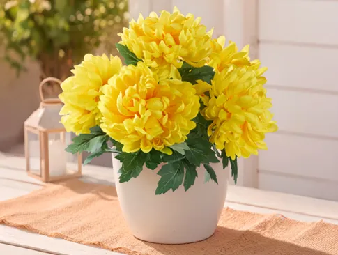 Gelbe Kunstblumen im Topf für eine leuchtende herbstliche Dekoration