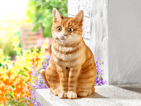 Dekofigur einer sitzenden Katze auf einer Fensterbank