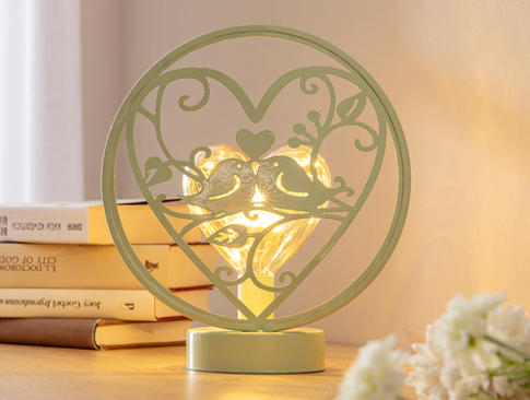 Herz-Lampe mit Vogelmotiv auf einem Tisch