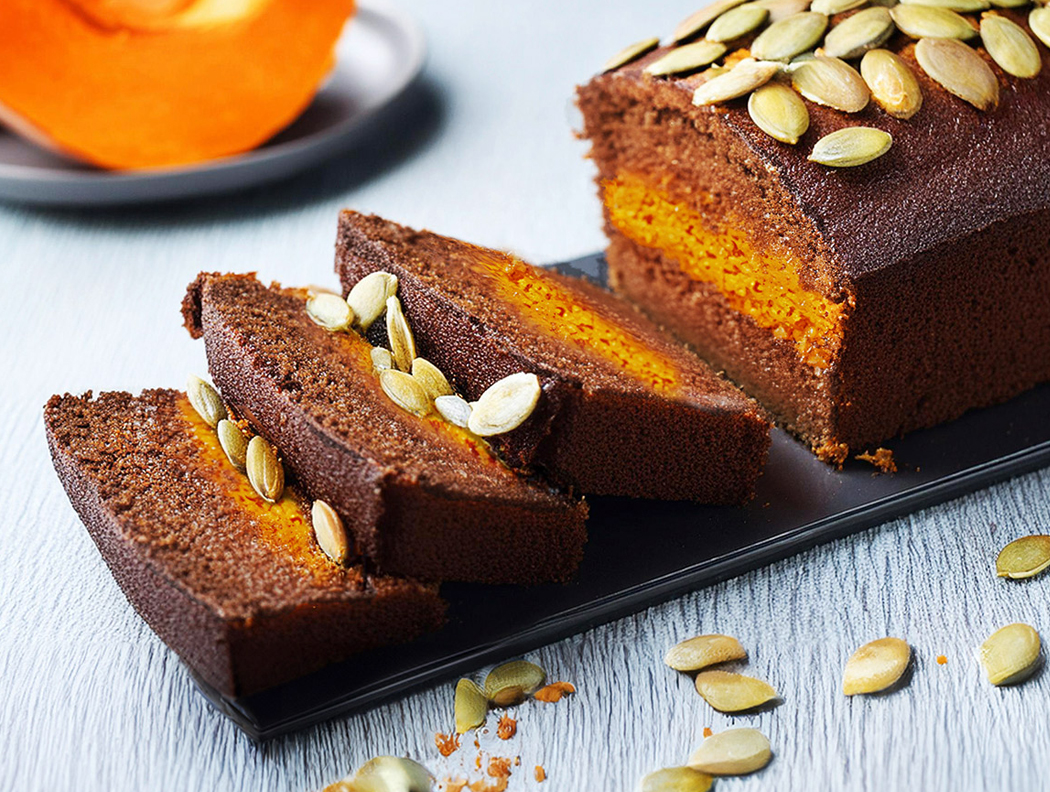 Schokoladenkuchen mit Kürbisfüllung und Kürbiskernen, serviert in Scheiben