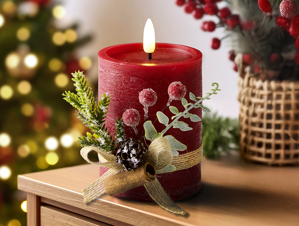 Rote Weihnachtskerze mit Tannenzweig und Dekoband