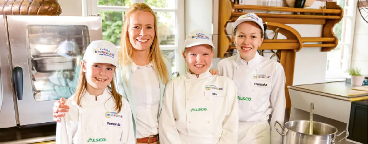 Jungborn-Marketing-Leitung mit drei Miniköchinnen in einer Küche