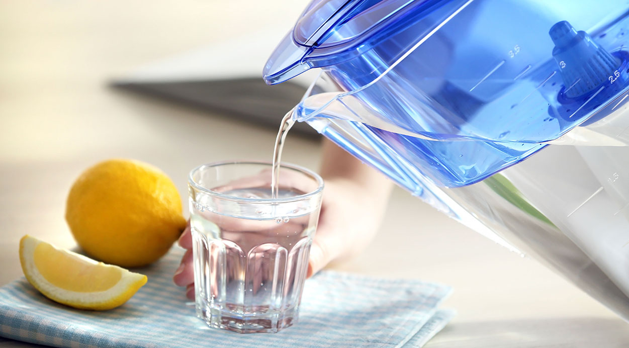 Wasser wird ins Glas gegossen