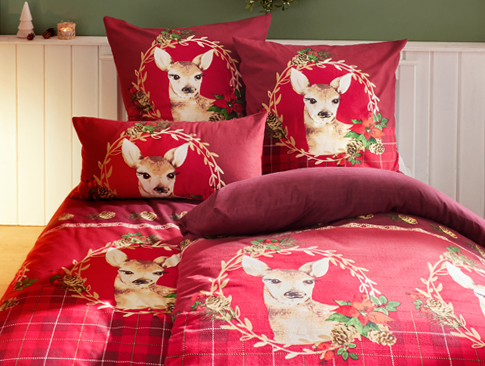 Weihnachtsbettwäsche in Rot mit Rehmotiv und Karo-Design im gemütlichen Schlafzimmer